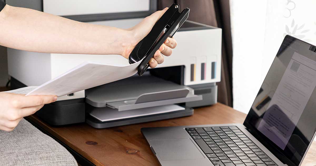 Gedruckte Dokumente werden nach dem Ausdruck am Schreibtisch weiterverarbeitet