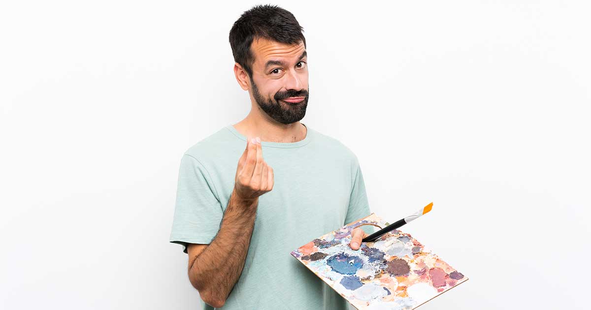 Junger Künstler hält Palette und zeigt Geld-Geste – Symbol für Finanzen in der Kulturbranche.