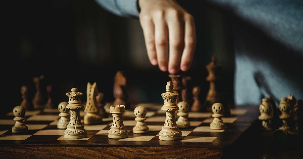 Hand bewegt eine Schachfigur auf einem Schachbrett – symbolisch für die psychologischen Entscheidungen in Stefan Zweigs Werken.