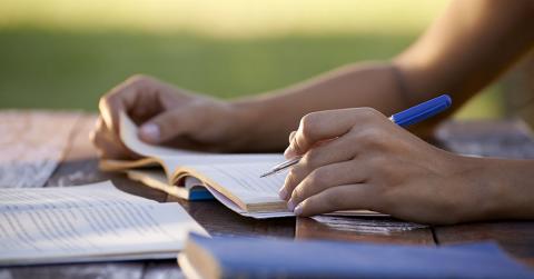 Bild zeigt Student mit Büchern beim Lernen